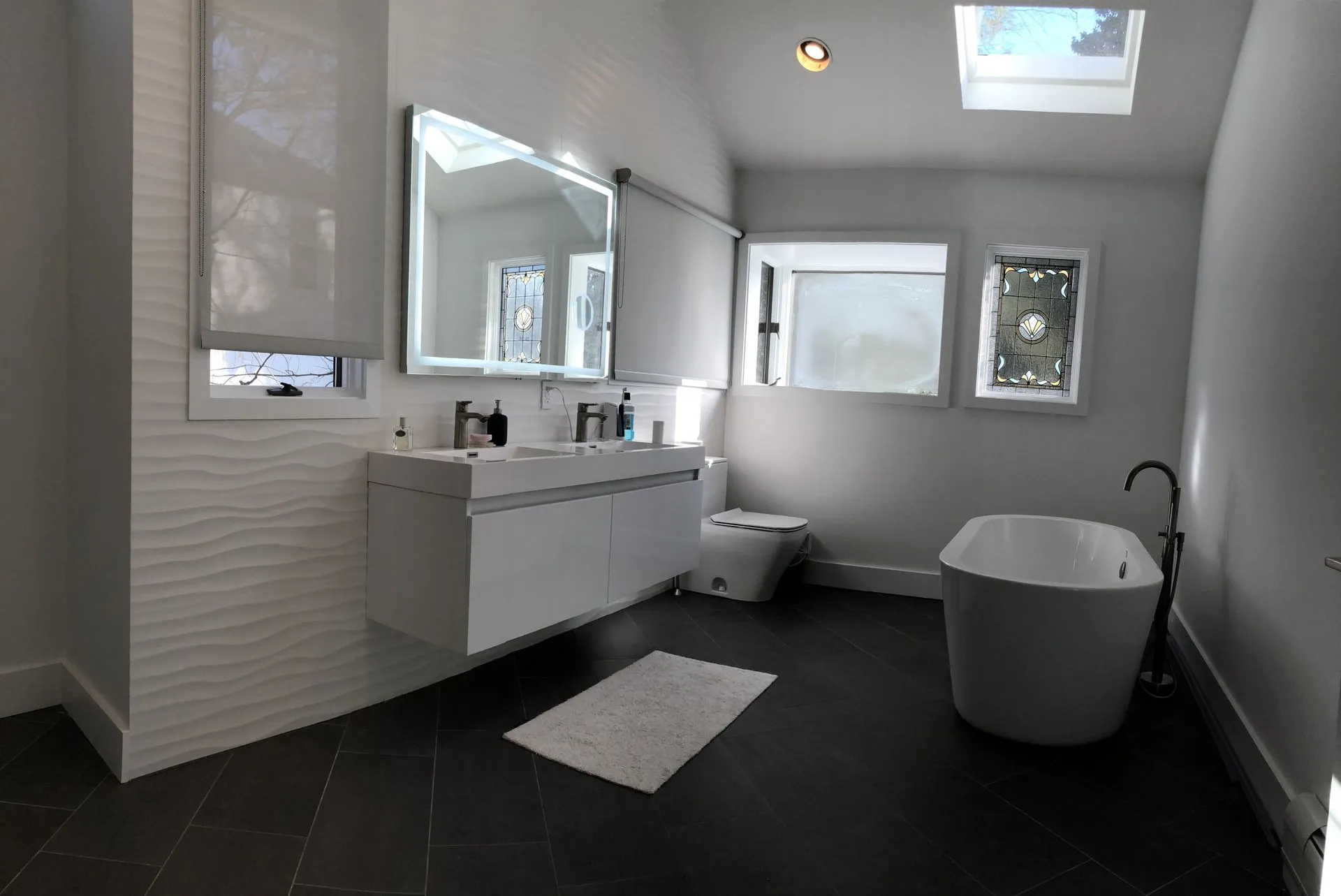 Master bathroom with freestanding tub, wave tile accent wall and skylight - Bergen County renovation