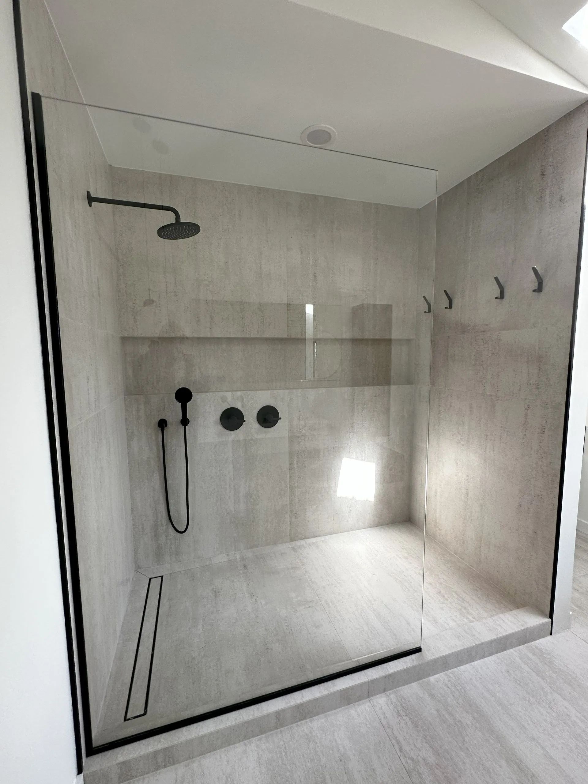Modern walk-in shower with matte black rain head and built-in niche - Bergen County remodel