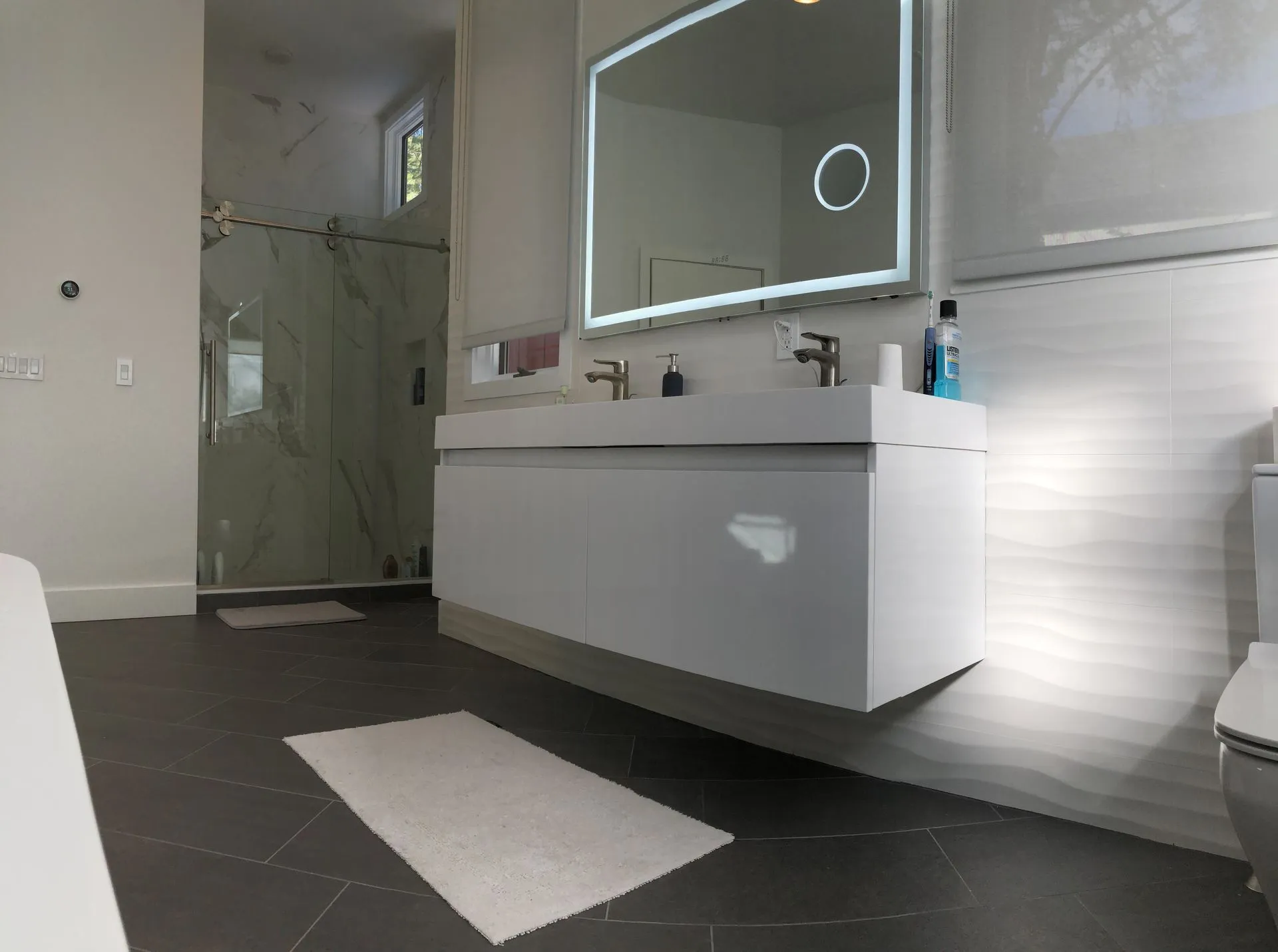Contemporary bathroom with LED mirror, floating vanity and wave tile wall - Bergen County project